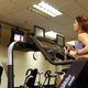 A woman watches TV at the gym